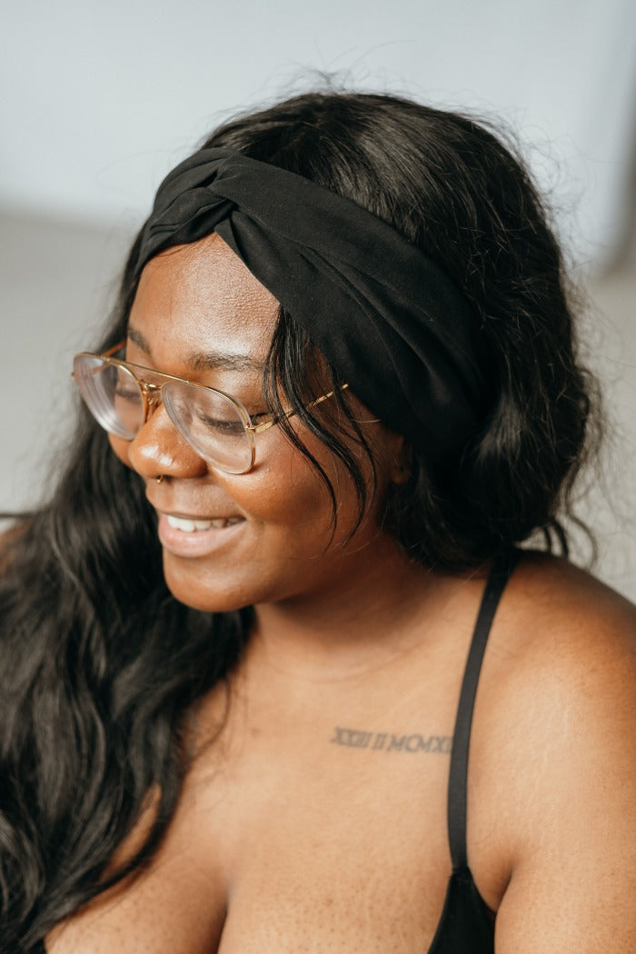 Model mit Piercing und Brille hat ein schwarzes Haarband in ihren langen Haare geknüpft.