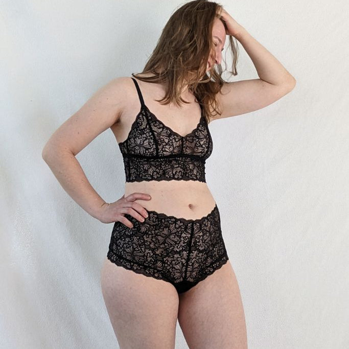 the woman appears in Joy slip  and Joy Bralette  in black and looks to the side
