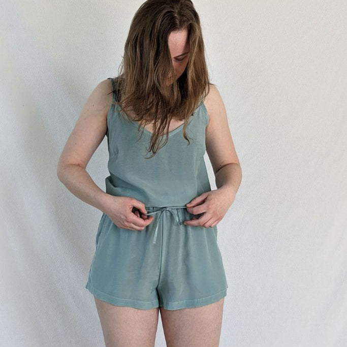the woman shows the Kat trousers in short and the Kat top in the color summer mint