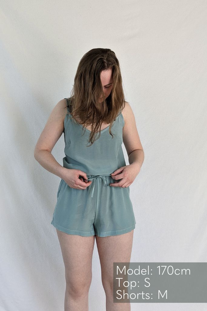 the woman shows the Kat trousers in short and the Kat top in the color summer mint