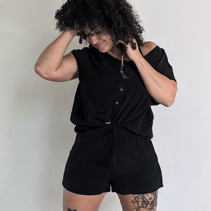The woman with the frizzy hair wears the Noe top and the Kat shorts made from sustainable materials