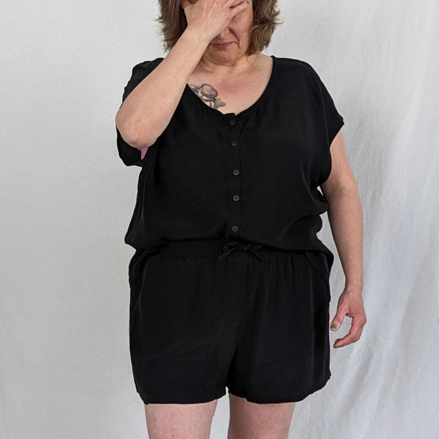 The model is wearing the buttoned-up Noe top made of cupro and viscose