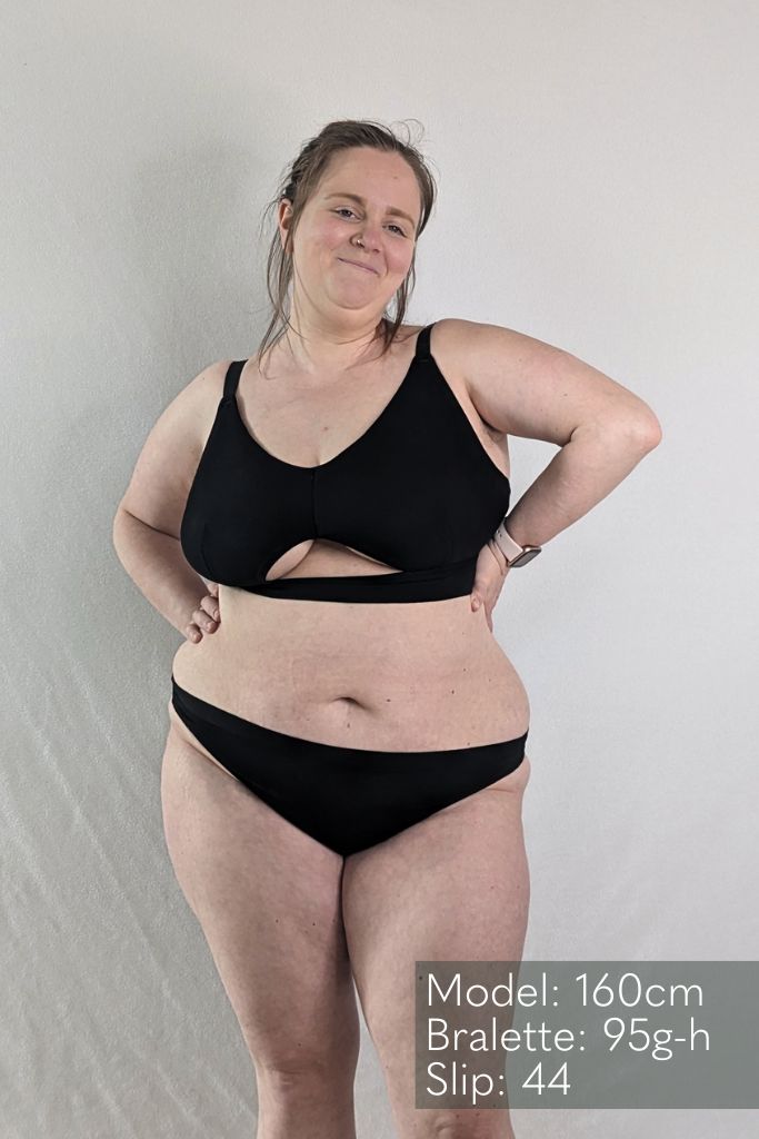 Das Model trägt das Bralette Thea mit schönem Cut out vorne in schwarz