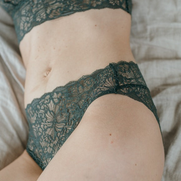 Close-up of slip Belle in dark green lace with a playful pattern