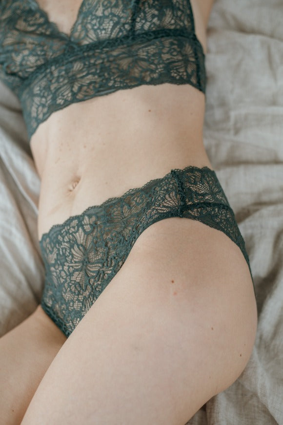 Close-up of slip Belle in dark green lace with a playful pattern