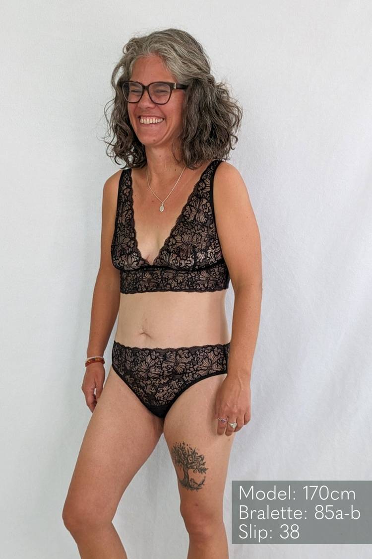 Femme en soutien-gorge et Slip en dentelle sourit joyeusement.