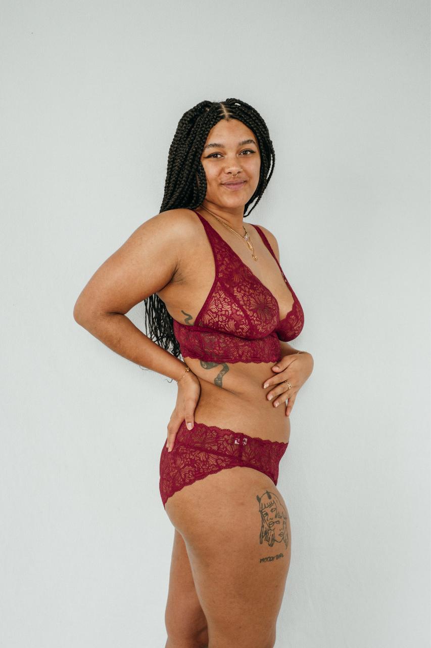 Bralette e pantaloni "Belle" in rosso rubino, fotografati di lato.