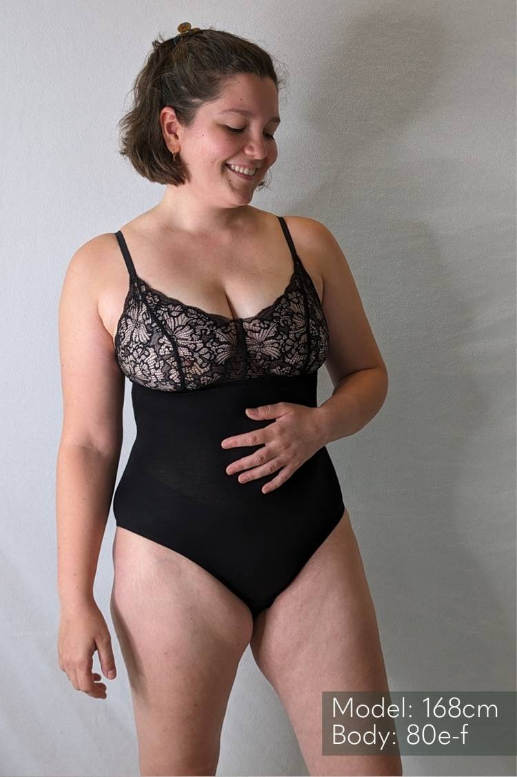 Le modèle porte un Body romantique en dentelle et en jersey Tencel doux. 