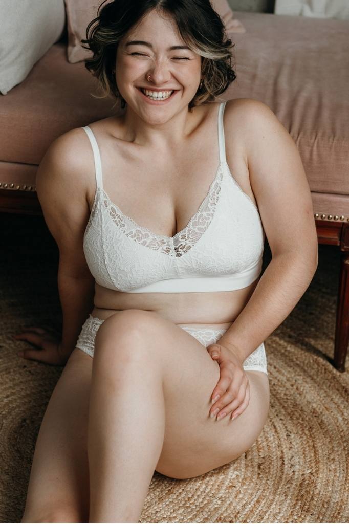 Model sits on the floor and wears white lace set Lana from thoughts of september.