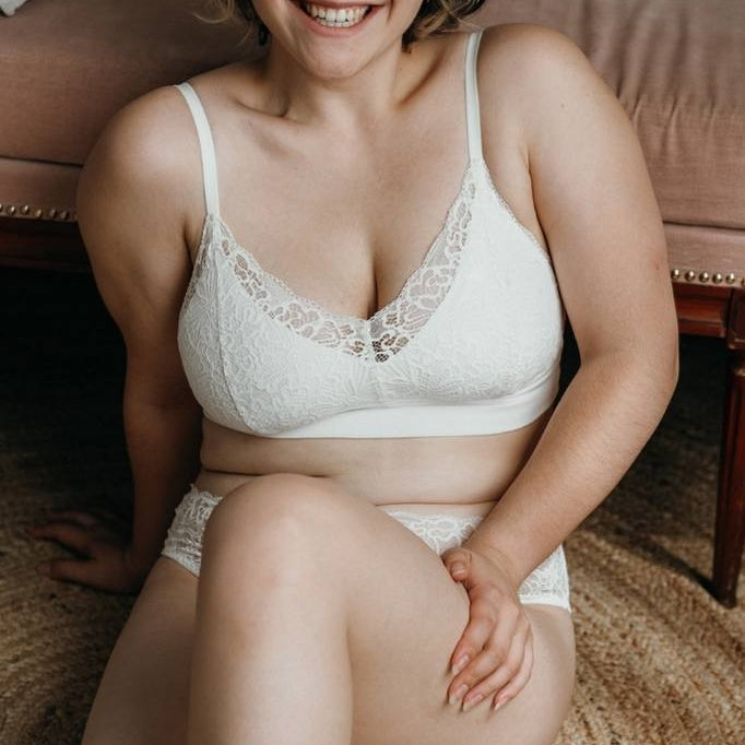 Model sits on the floor and wears white lace set Lana from thoughts of september.