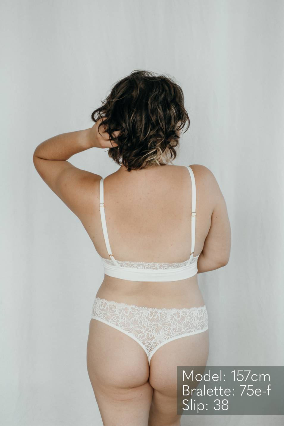 Fine String made of white lace worn by a woman with short hair.