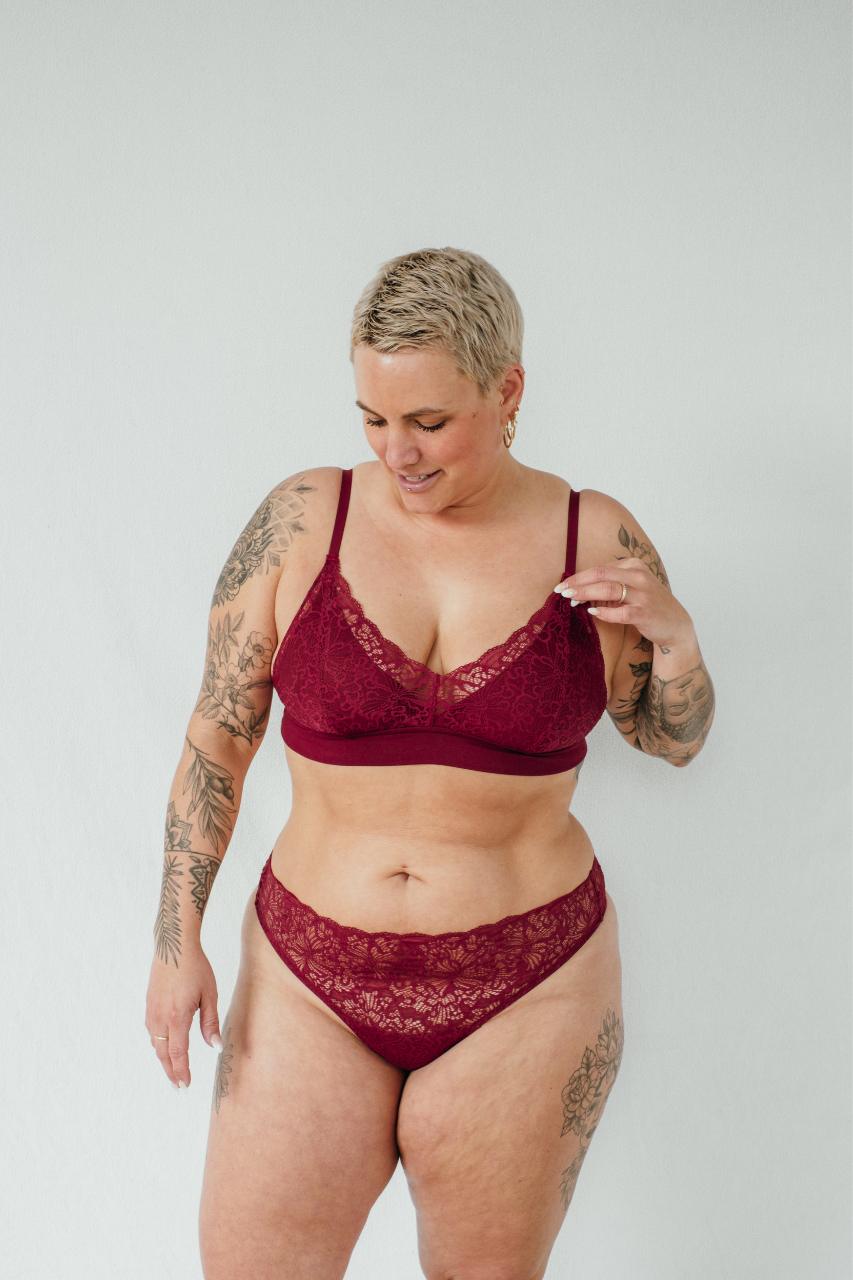 Le mannequin présente l'ensemble de lingerie rouge Lana et montre la fine dentelle.