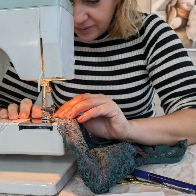 eine Frau näht gerade an ihrem Bralette an der Nähmaschine