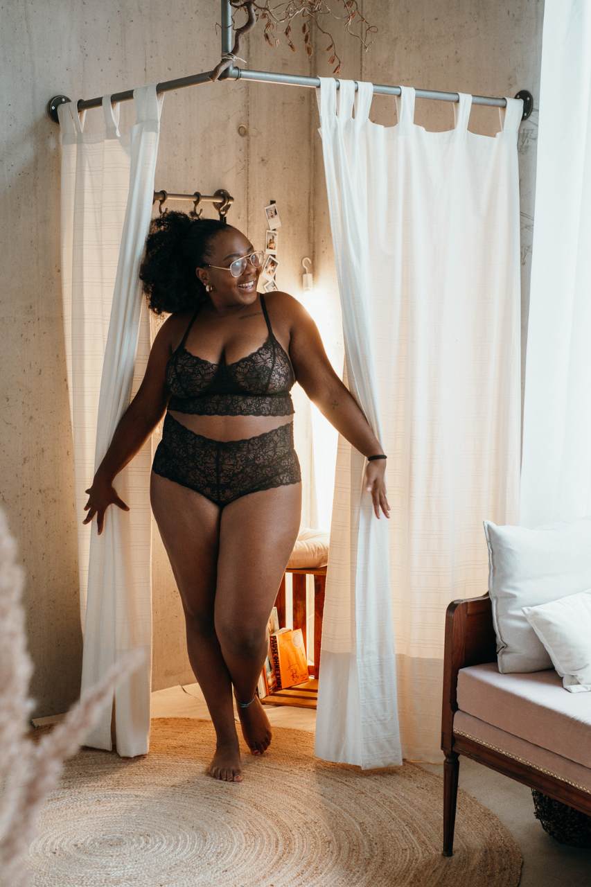 Modella in biancheria intima sostenibile di pizzo nero esce dallo spogliatoio