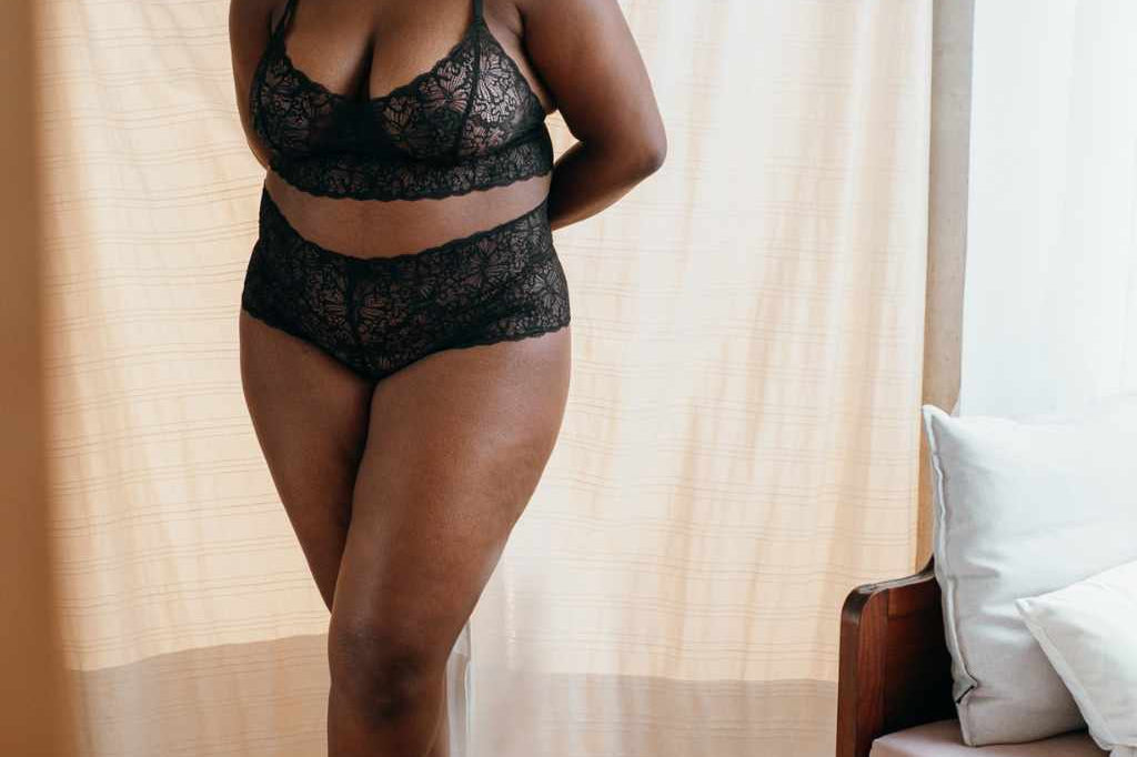 Model in schwarzem Dessous steht vor Umkleidekabine im Studio von thoughts of september