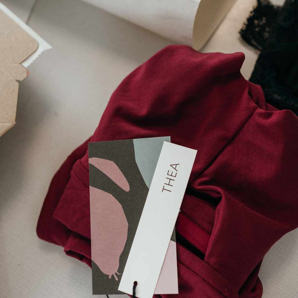 Ein rotes Bralette aus Tencel Lyocell liegt gefaltet auf dem Tisch.