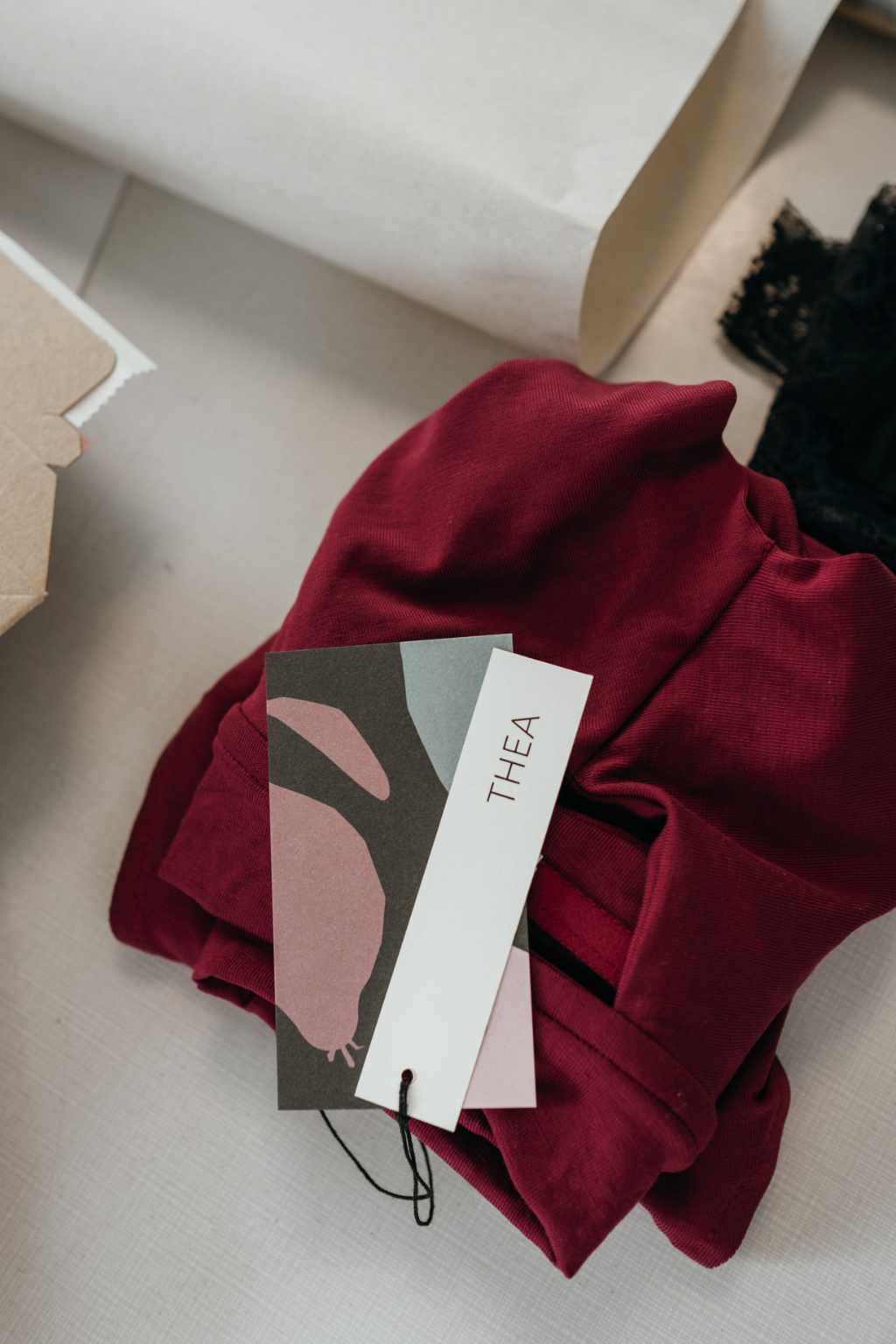 Il reggiseno rosso in Tencel Lyocell sostenibile è piegato su uno sfondo grigio. 