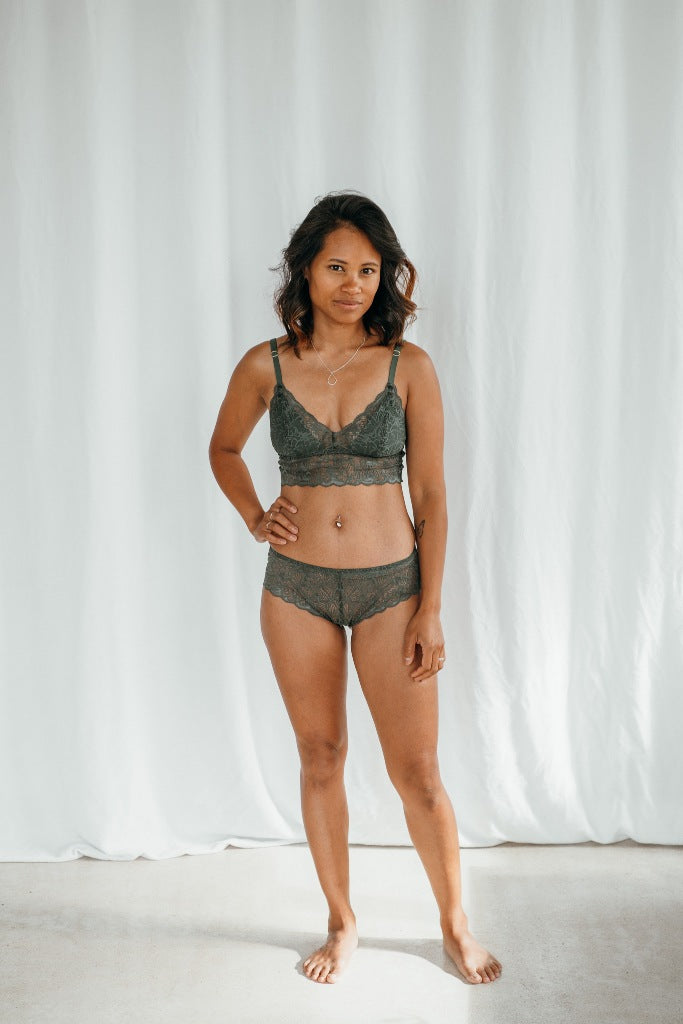Model wears Vivi Bralette with removable pads and matching slip in dark green lace.