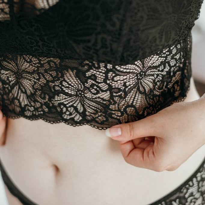 Close-up of the black lace that casts fine shadows on the skin.