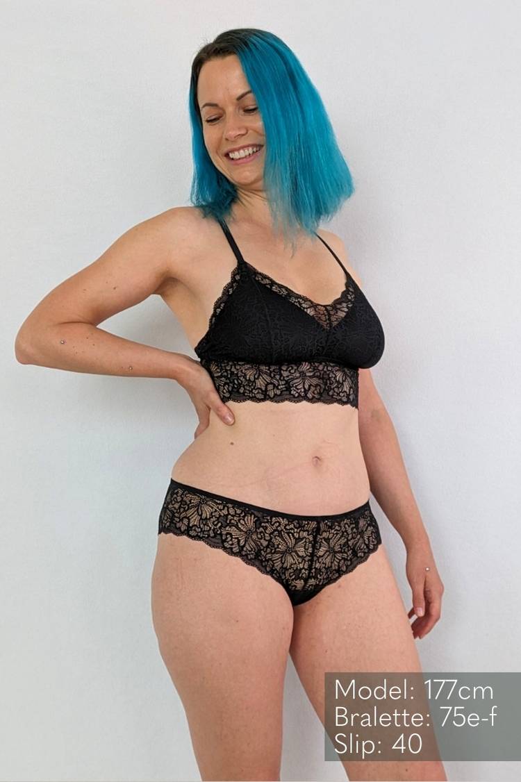 Woman with blue hair wears Bralette with removable pads in size 75 e-f made of black lace.