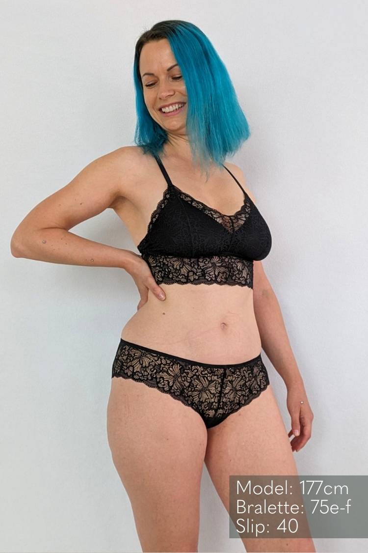 Une femme aux cheveux bleus porte Bralette avec des coussinets amovibles taille 75 e-f en dentelle noire.