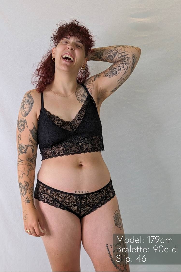 Model with curls laughs in the romantic Vivi lace set.