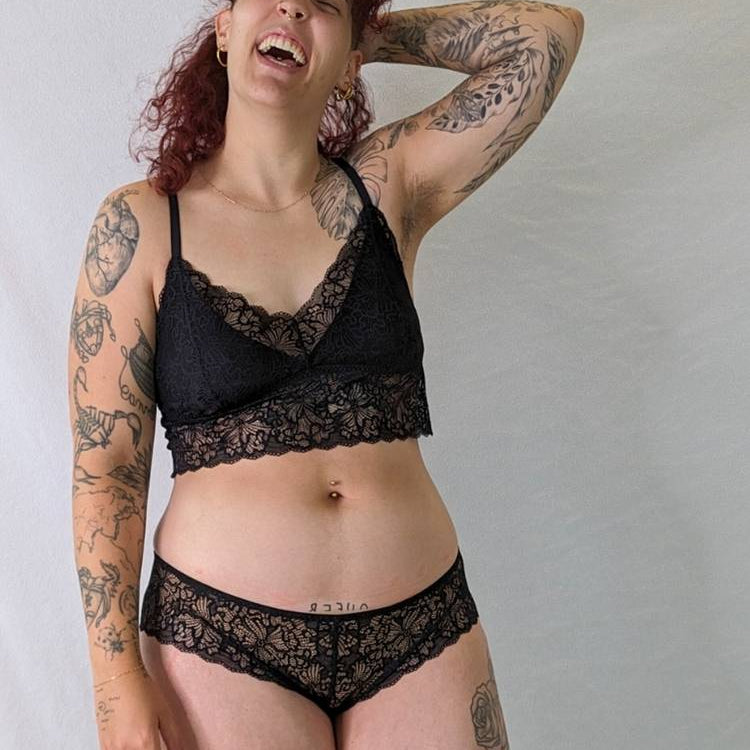Model with curls laughs in the romantic Vivi lace set.