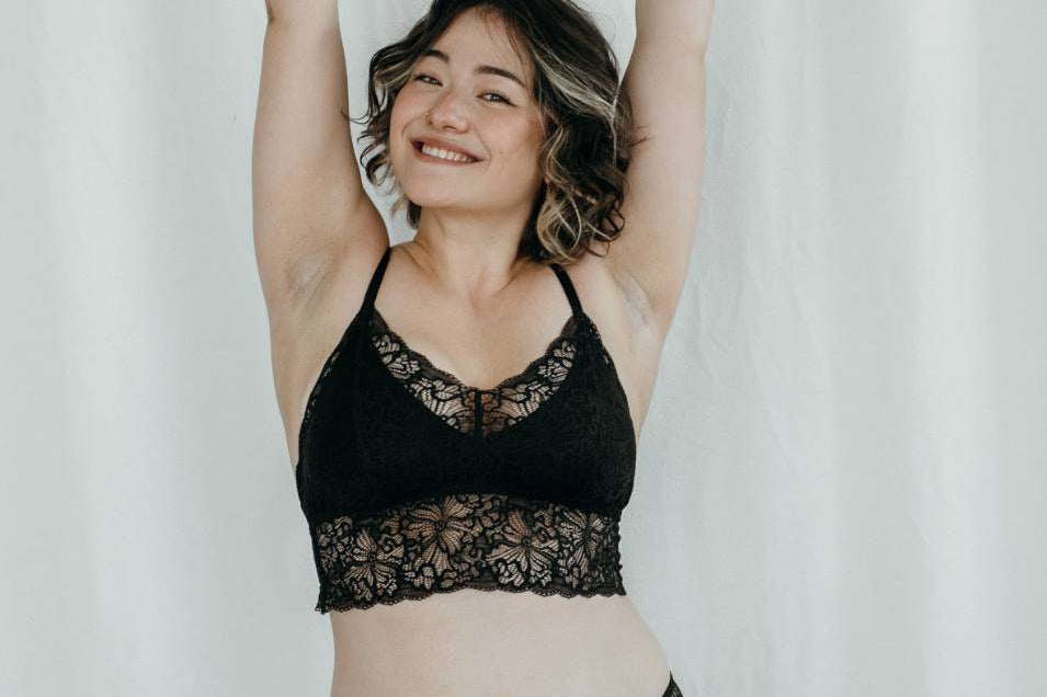 Fröhliches Model Trägt Bralette Vivi mit herausnehmbaren Pads in schwarz.