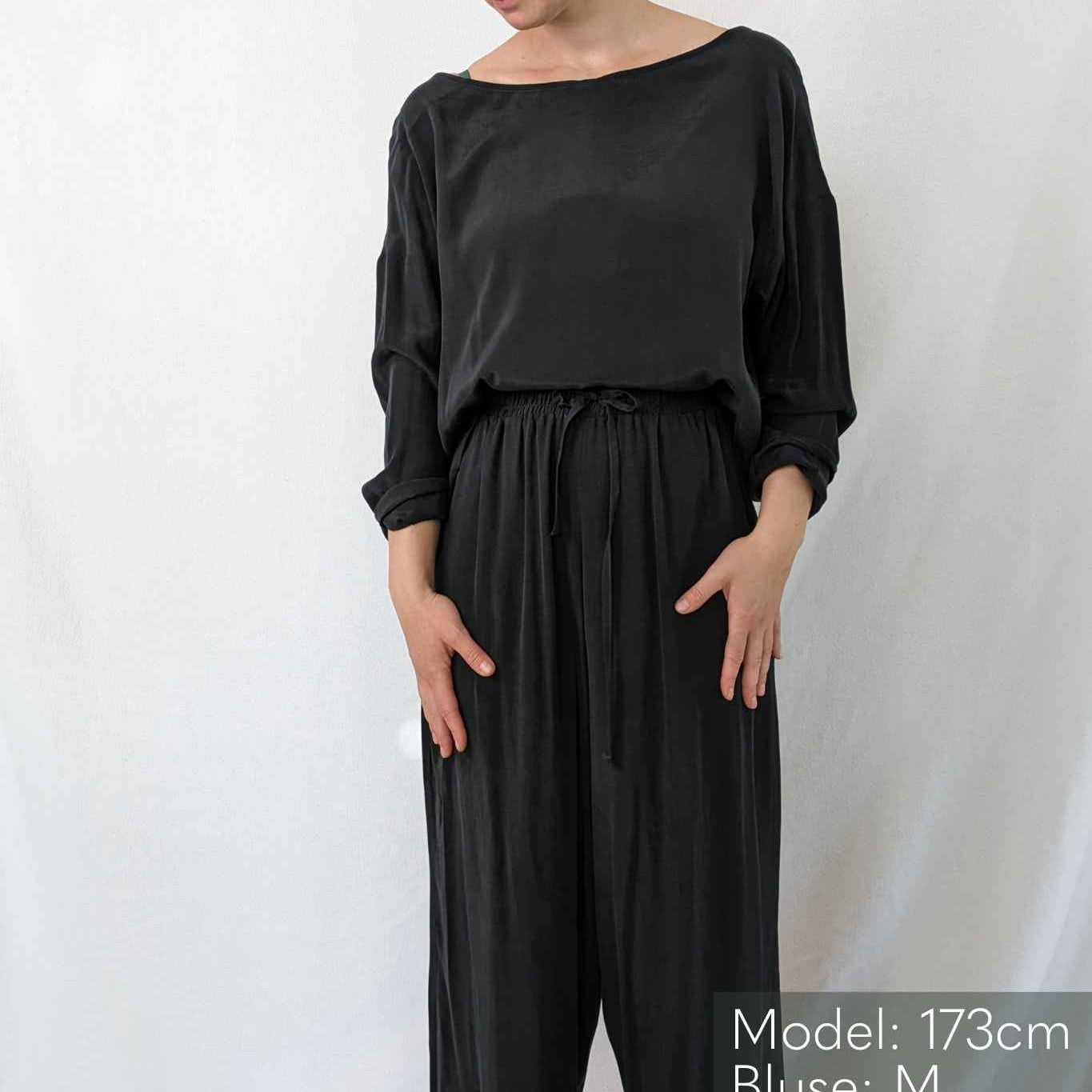 Woman wears vegan silk pyjamas.