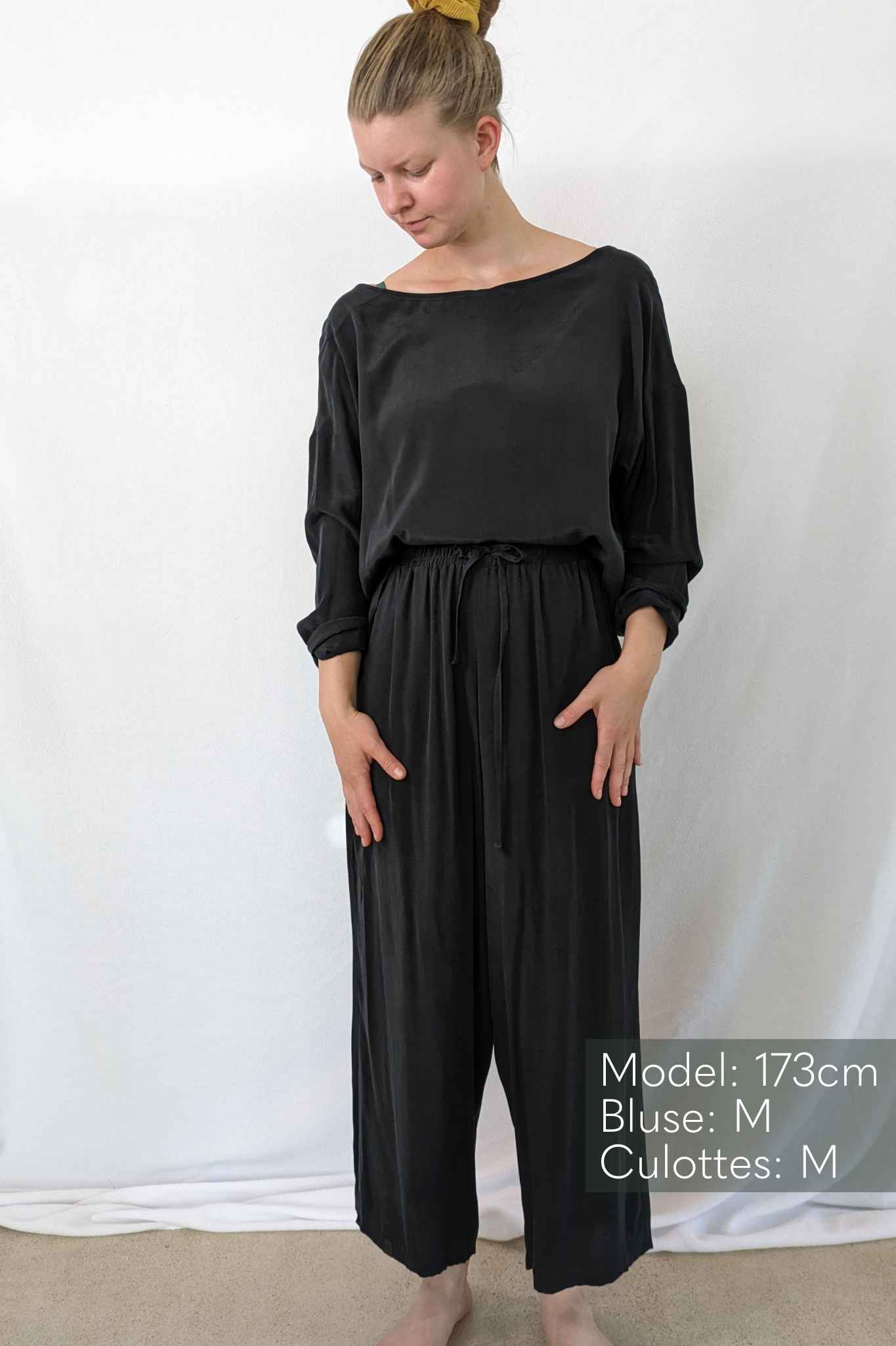 Woman wears vegan silk pyjamas.