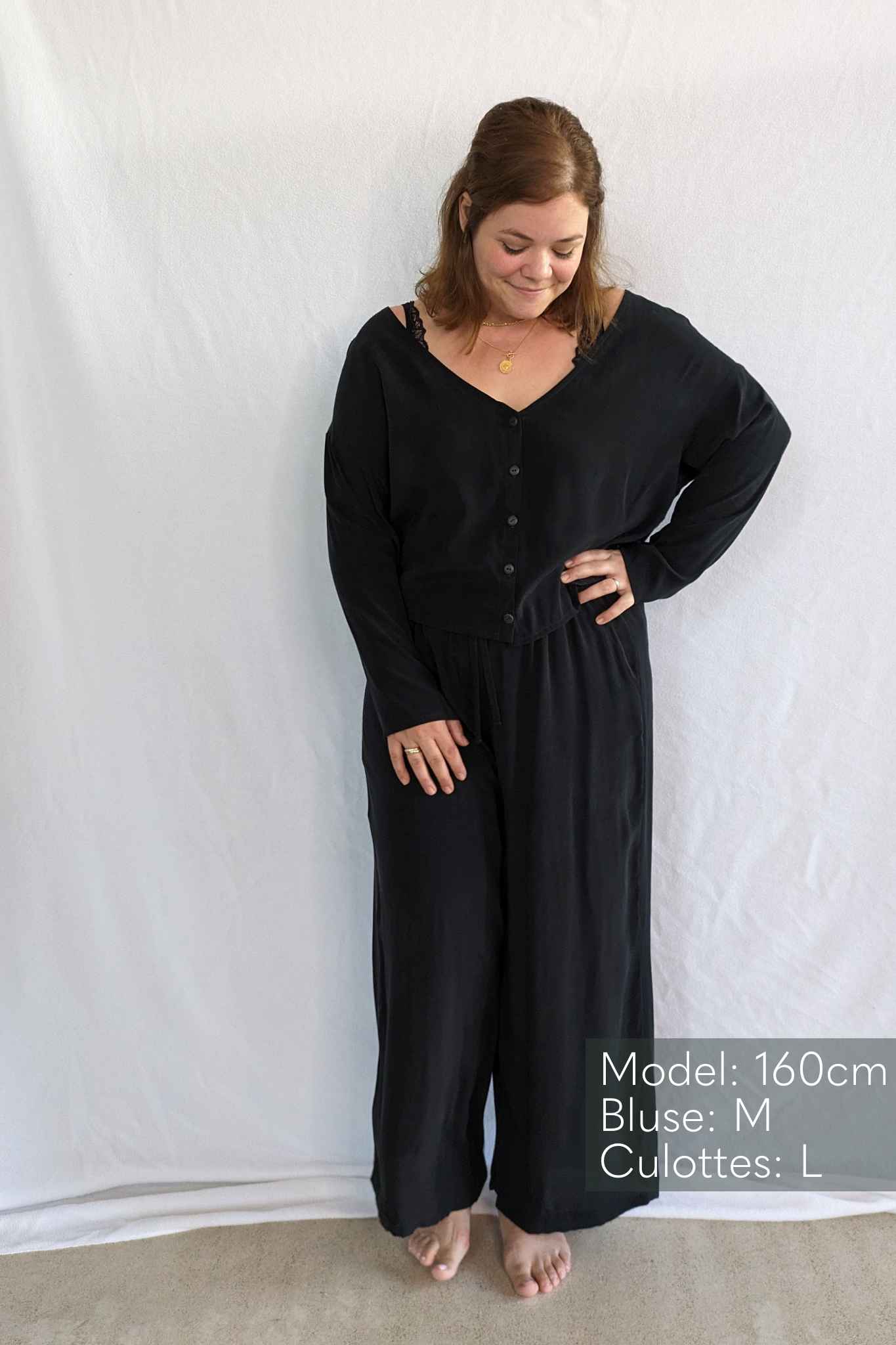 Person wears black pyjamas with small buttons down the front.