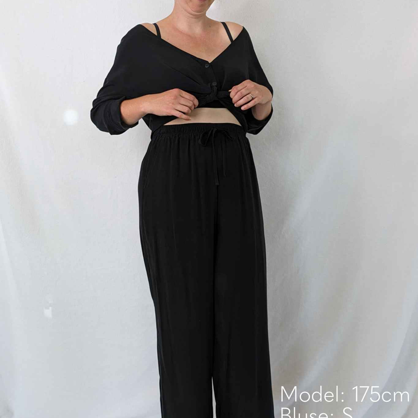 Woman tying her pyjamas from thoughts of september in front of her stomach.