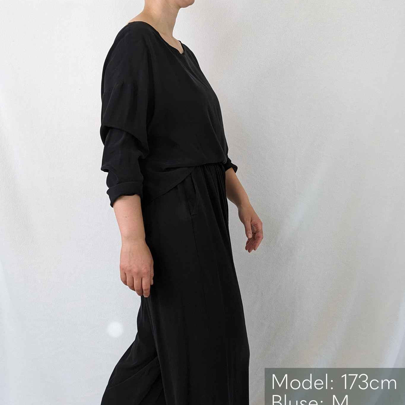 Woman walks in front of the camera in black pajamas
