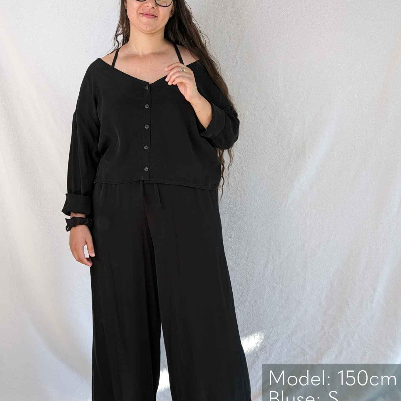 Woman with long hair wears the Coco pyjamas in black.