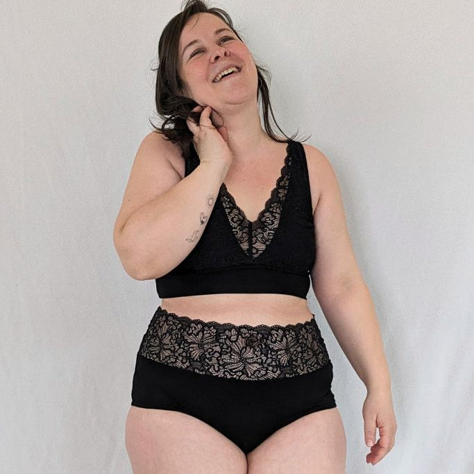 Frau trägt wunderschönes Bralette mit dem dazugehörigen Slip in schwarz
