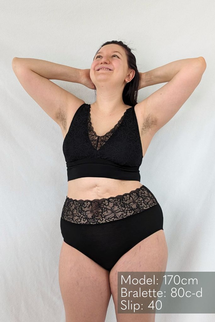 Model mit schwarzem BH und schwarzer Unterhose schaut an die Decke