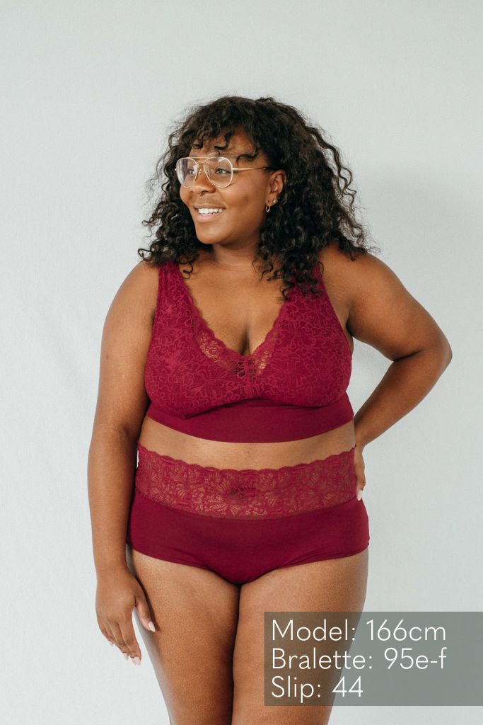 Modell mit Brille trägt das Modell "Nelly" aus feinster Spitze und Lyocell Tencel ind Rubin rot