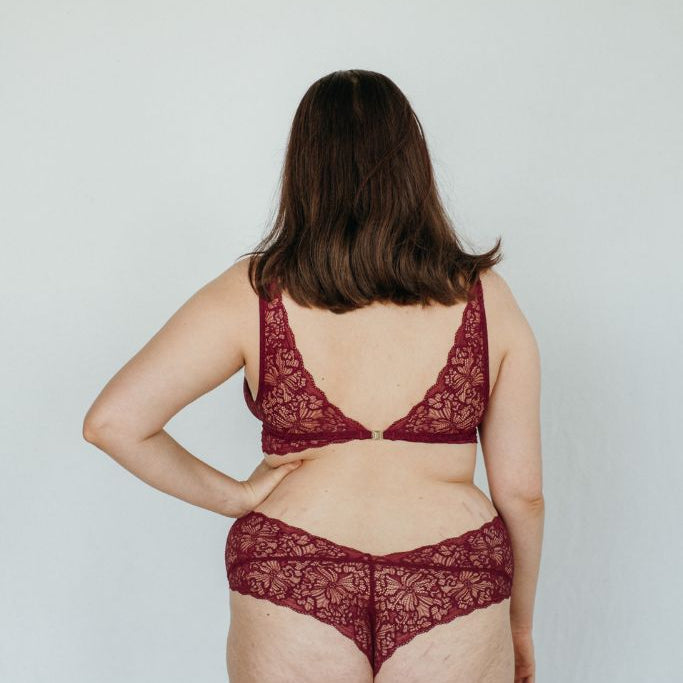 Das Model trägt ein hohes Höschen und einen büstenhalter in ruby red 