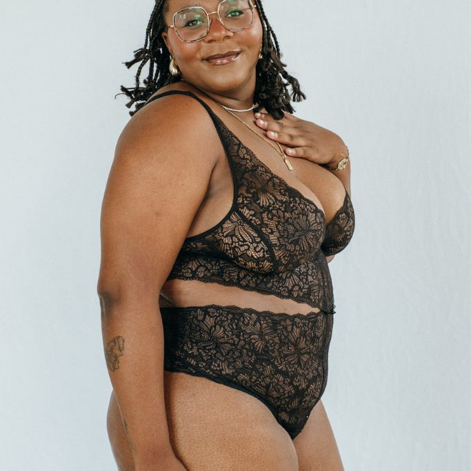 das Model trägt den Body Alison in schwarz, den man vornen zusammenknöpfen kann
