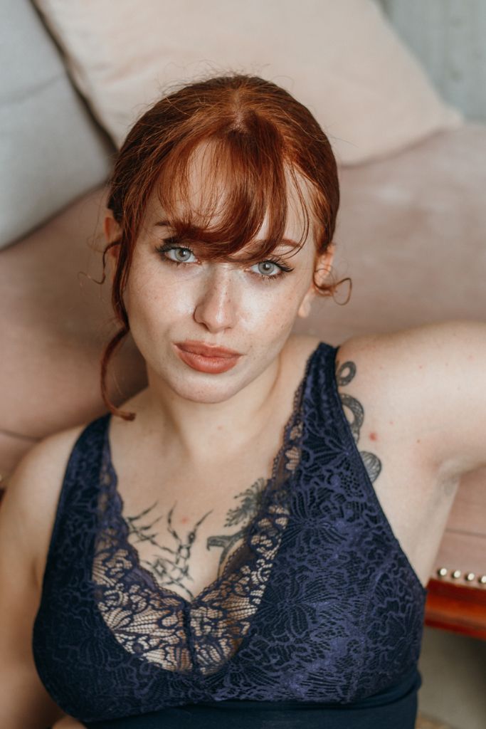 das Model mit den roten Haaren schaut in die Kamera und trägt das Wunderschöne Oberteil Nelly in nacht blau
