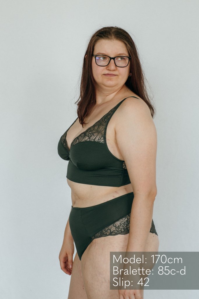 die Frau zeigt sich seitlich im Unterwäsche Set aus recycelter Spitze und Tencel Lyocell in jade grün