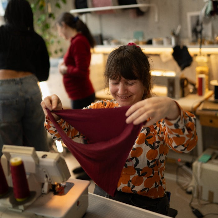 La signora esamina le sue mutandine rosso rubino in officina