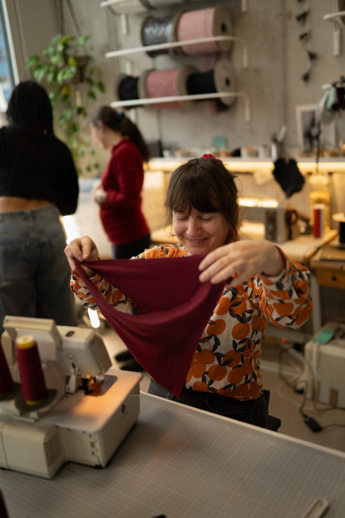 La signora esamina le sue mutandine rosso rubino in officina