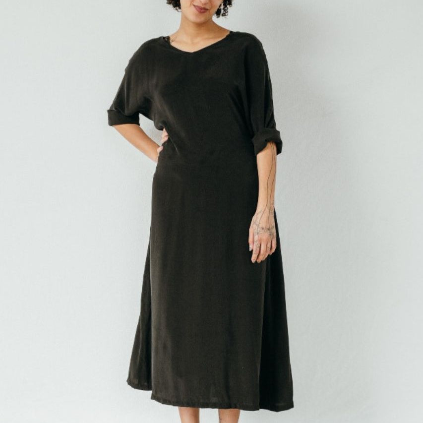 La modella indossa la vestaglia Kim di colore nero e appoggia la mano sul fianco.