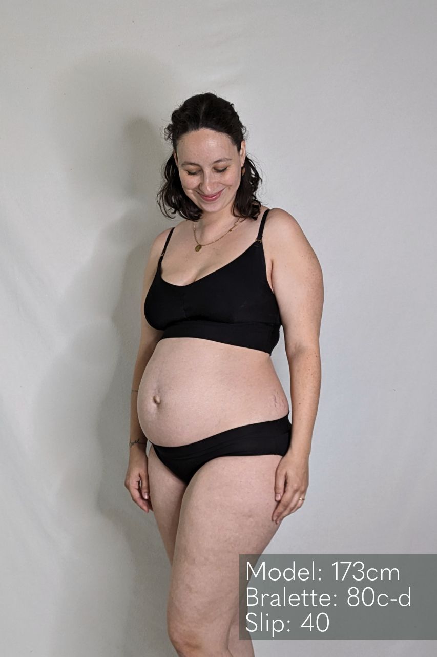die schwangere Frau trägt das Emma Höschen und das Mama Emma Bralette in der Farbe schwarz