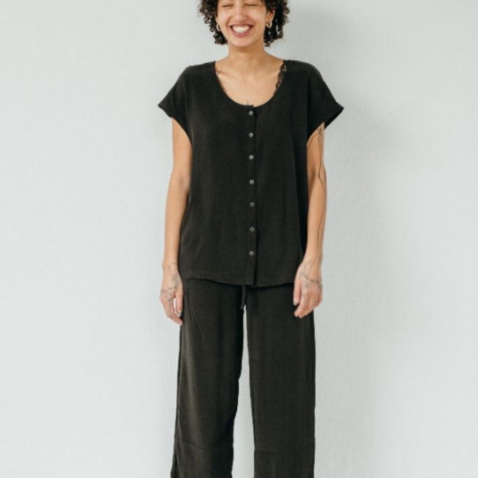 the woman with the curls wears the Noe top and Coco trousers made from the sustainable material cupro and viscose