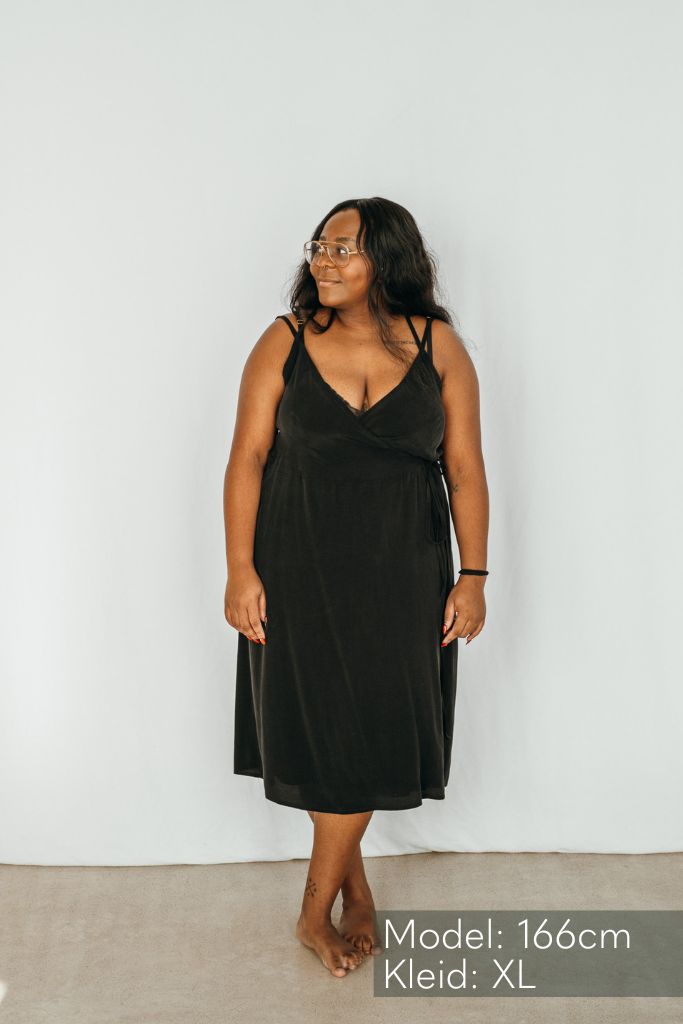 Das Model schaut zur Seite und trägt das Kleid Zia in schwarz