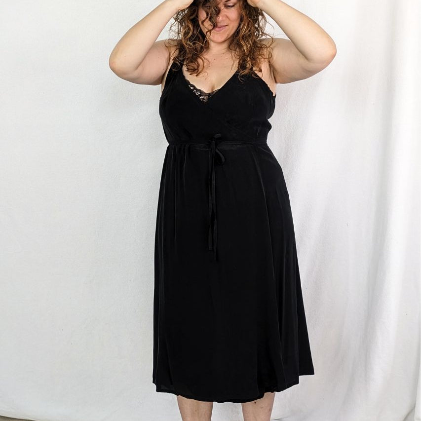The model stands in front of the camera wearing the beautiful Zia slip dress in black