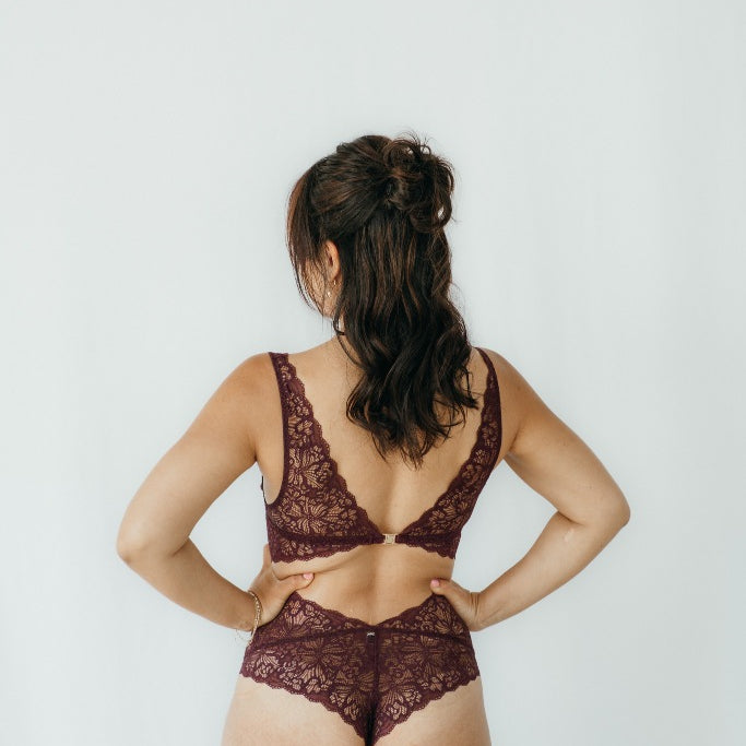 Model trägt Alison Body in der Farbe Aubergine, ihr Rücken ist der Kamera zugewandt.