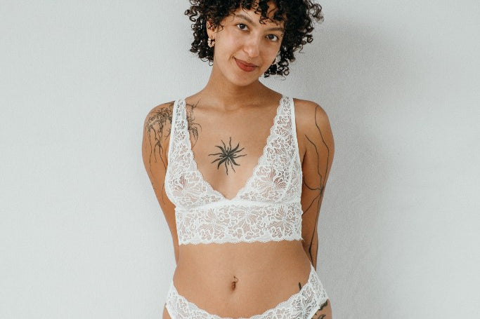 die Frau auf dem Foto trägt weisse Unterwäsche aus Top und Unterhose in der Farbe weiss